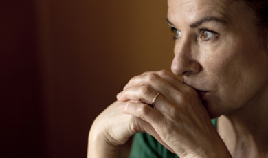 Thoughtful lonely mature woman looking away at home during curfew