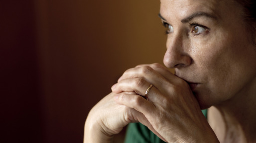 Thoughtful lonely mature woman looking away at home during curfew