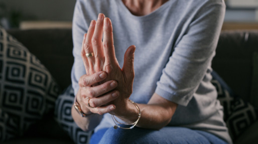 senior vrouw met artritis in handen