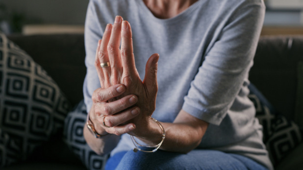 senior vrouw met artritis in handen