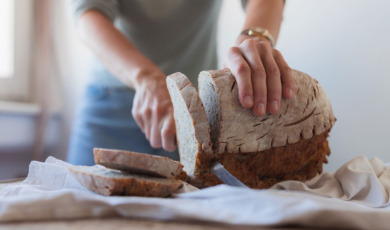 vrouw snijdt brood