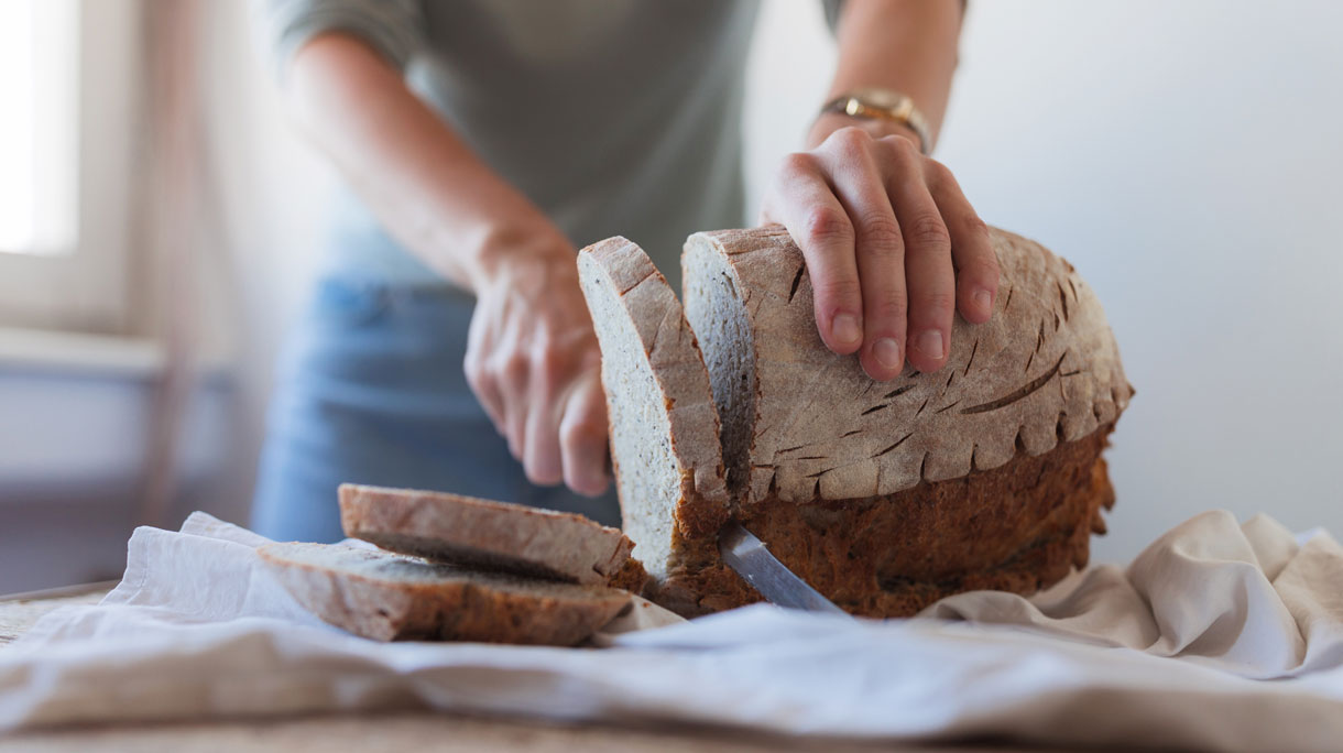 vrouw snijdt brood