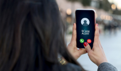 Vrouw met tekst Scam Alert op haar smartphone, phishing en oplichting
