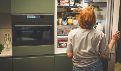 Vrouw voor open koelkast