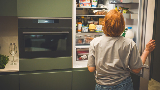 Vrouw voor open koelkast