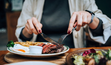 Vrouw eet in resaurant biefstuk