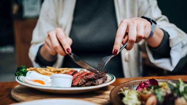 Vrouw eet in resaurant biefstuk