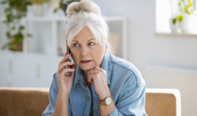 oudere vrouw kijkt bezorgd tijdens bellen