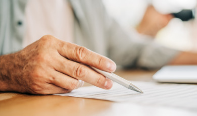 man met pen in hand tekent testament