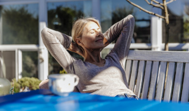 50 plus vrouw geniet van herfstzon