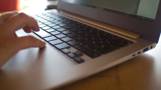 Iemand werkt achter laptop