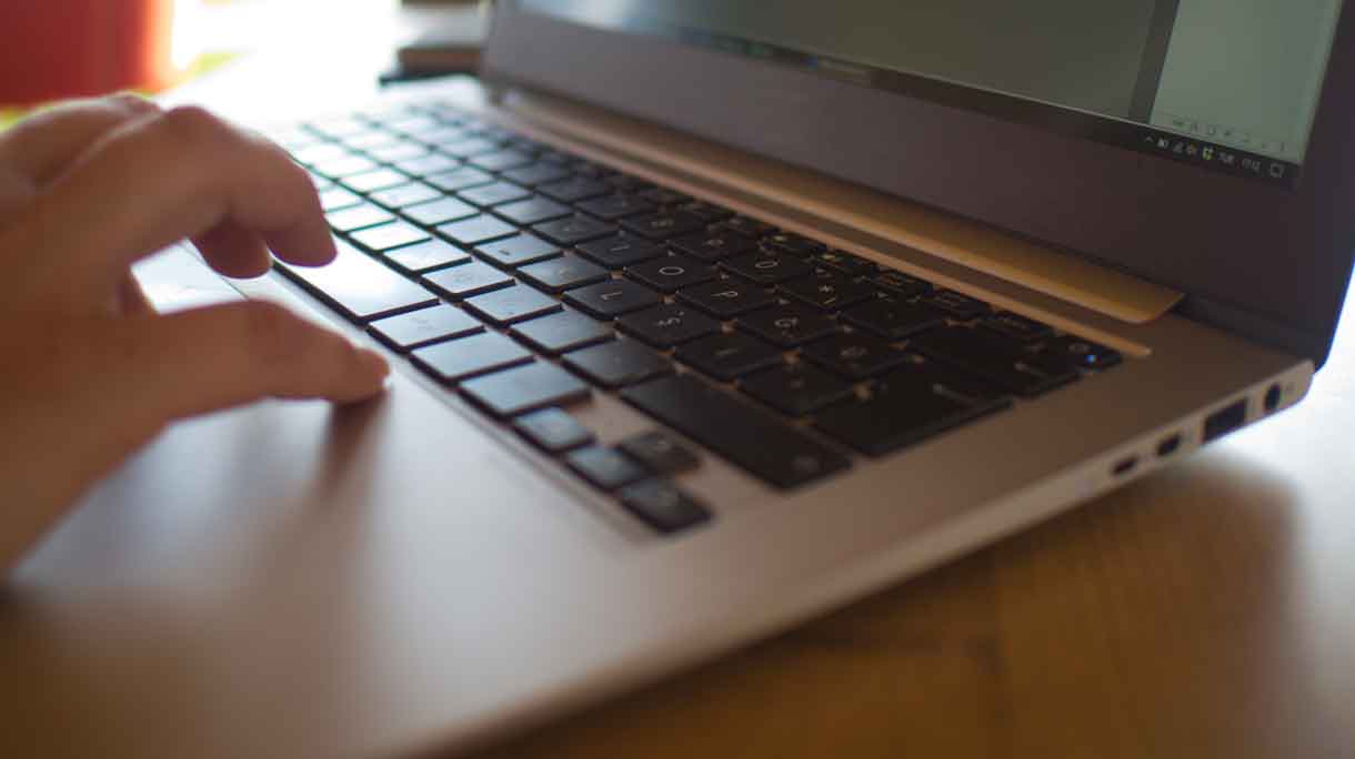 Iemand werkt achter laptop