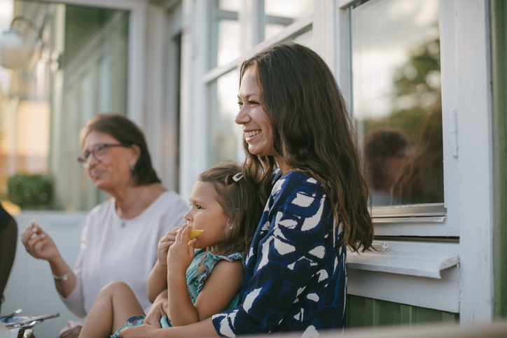 Vrouw met kind en familie op terras