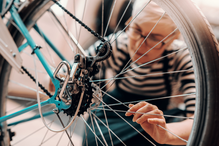 Vrouw repareert fiets in fietsenwinkel