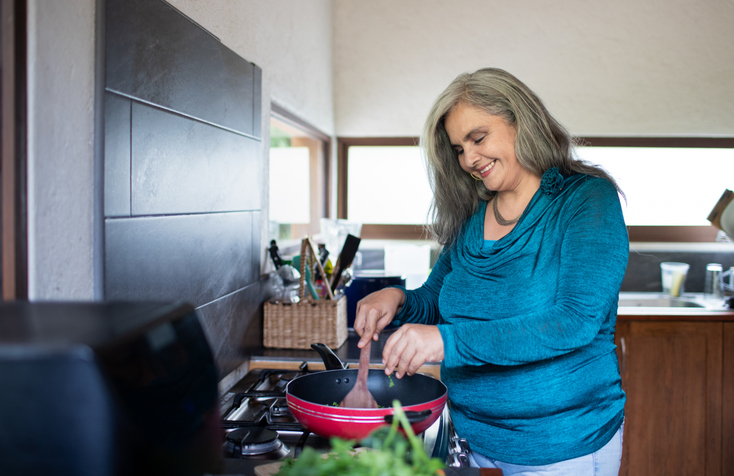 Vrouw is in de keuken aan het wokken