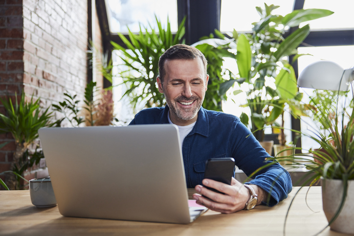 Man met laptop en smartphone