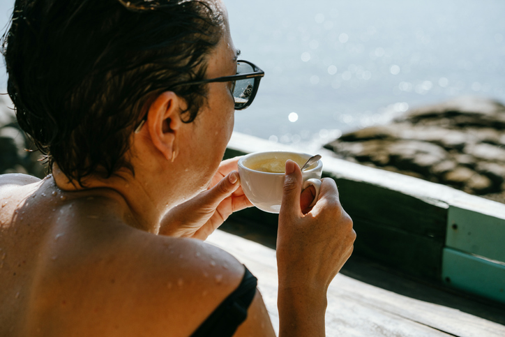 Vrouw zit in Thailand aan de koffie op een terras