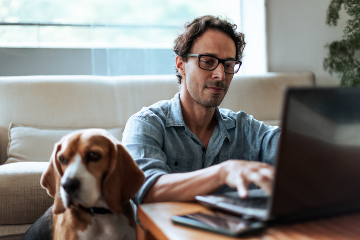 Man met hond achter computer
