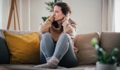 Vrouw zit op bank maakt zich zorgen