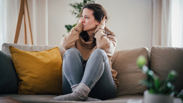 Vrouw zit op bank maakt zich zorgen
