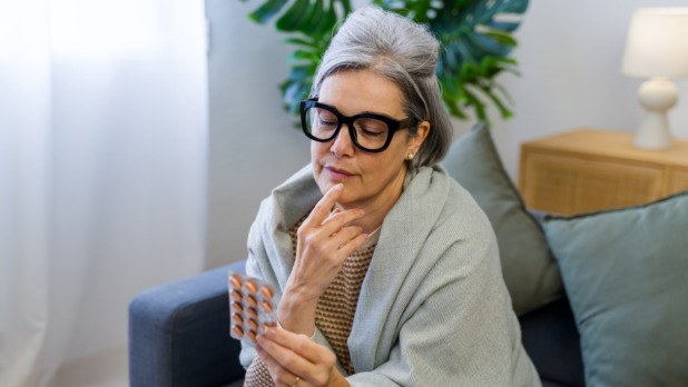 50 plus vrouw kijkt naar pillen