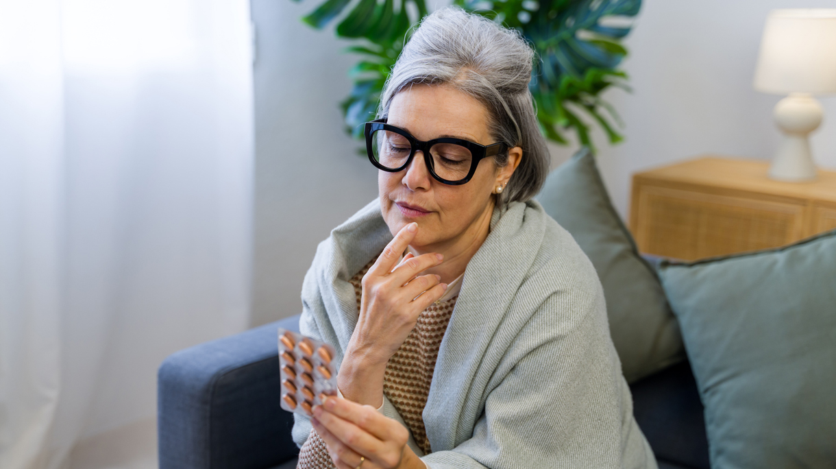 50 plus vrouw kijkt naar pillen