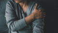 oudere vrouw houdt schouder vast