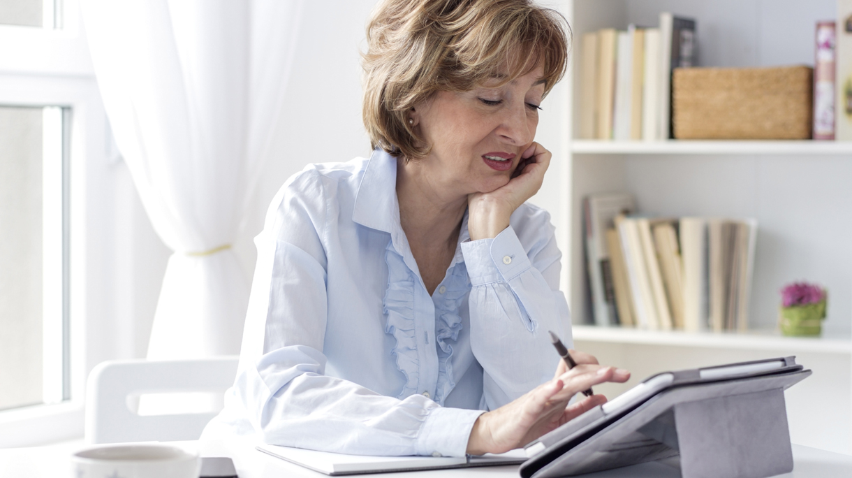 50 plus vrouw kijkt naar agenda op iPad