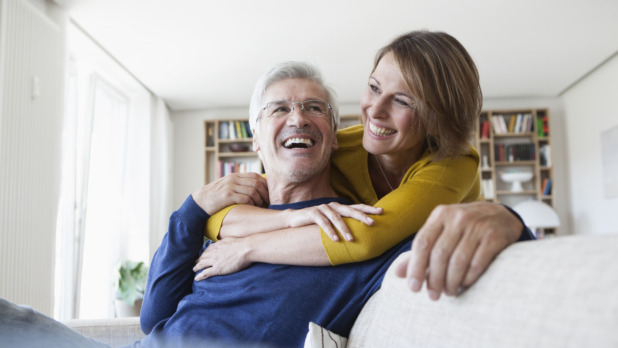 Man en vrouw knuffelen op de bank