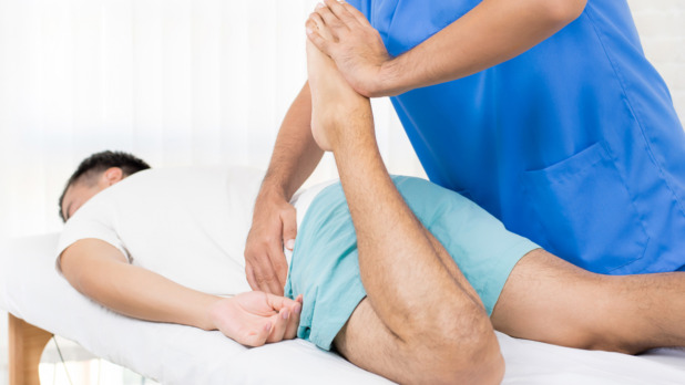 Man met pijn in zijn hamstring en onderrug