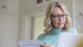 50 plus vrouw checkt papieren