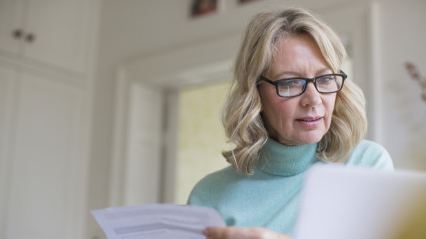 50 plus vrouw checkt papieren