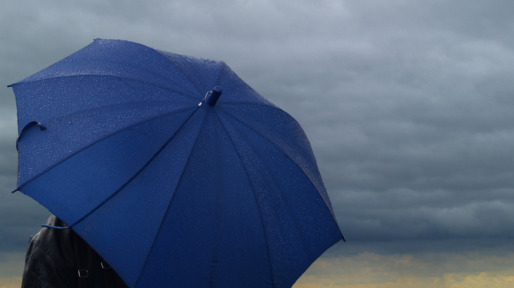 Blue umbrella over a dark stormy cloud